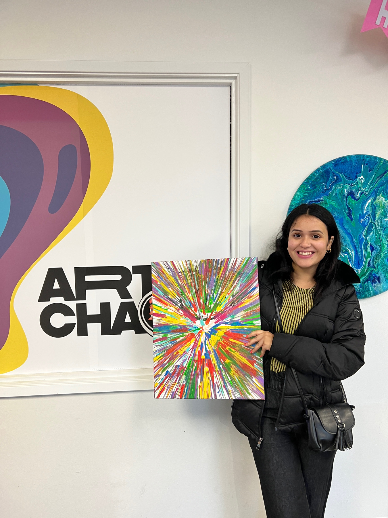 Ritu holding a colorful spin art painting